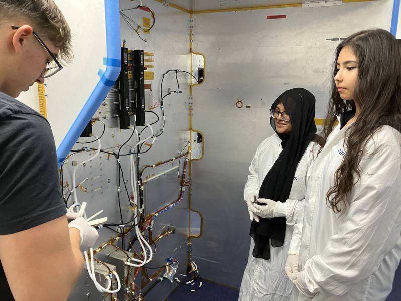 Students watch an employee at work.