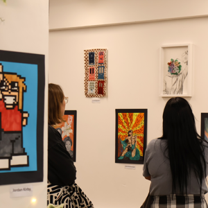 Members of the public viewing the Playland exhibition by COPC art and design students