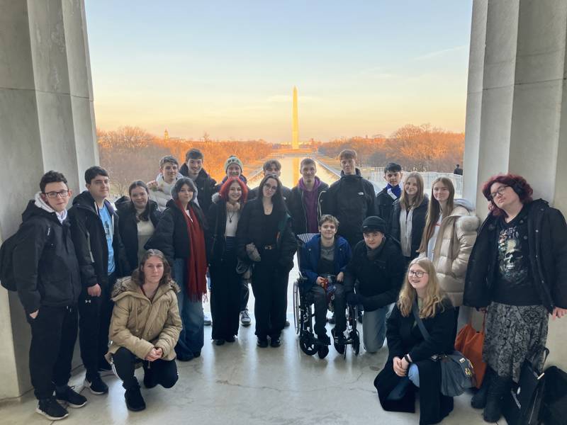 A group of students seen with the Washington Monument in the background.