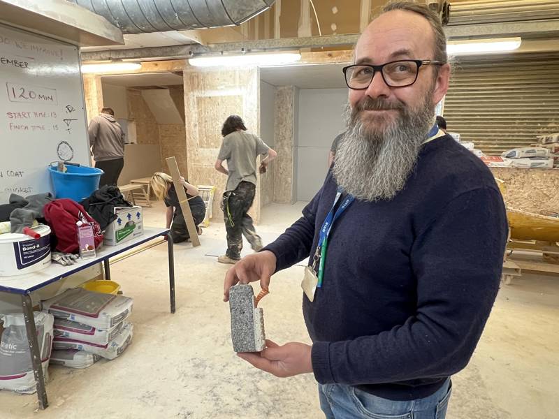 Plastering lecturer Paul Herbert seen with a sample of monocouche silicone render.