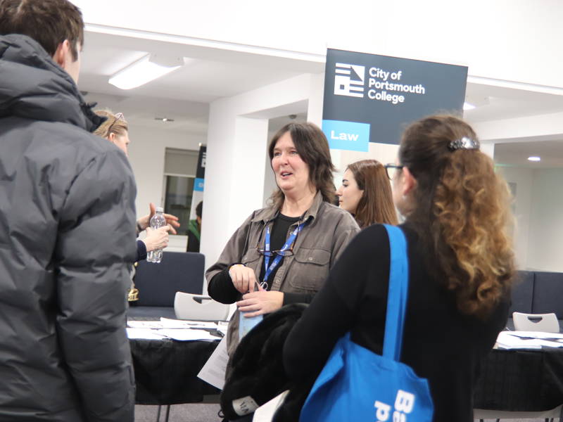 Lecturer talking to prospective students at college Open Event.