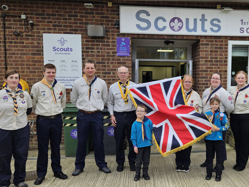 Members of the Hawk District (Havant and Waterlooville) Scout Group, seen with the ceremonial flag donated by City of Portsmouth College.