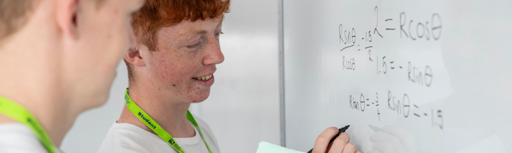 A student writing maths on a whiteboard 