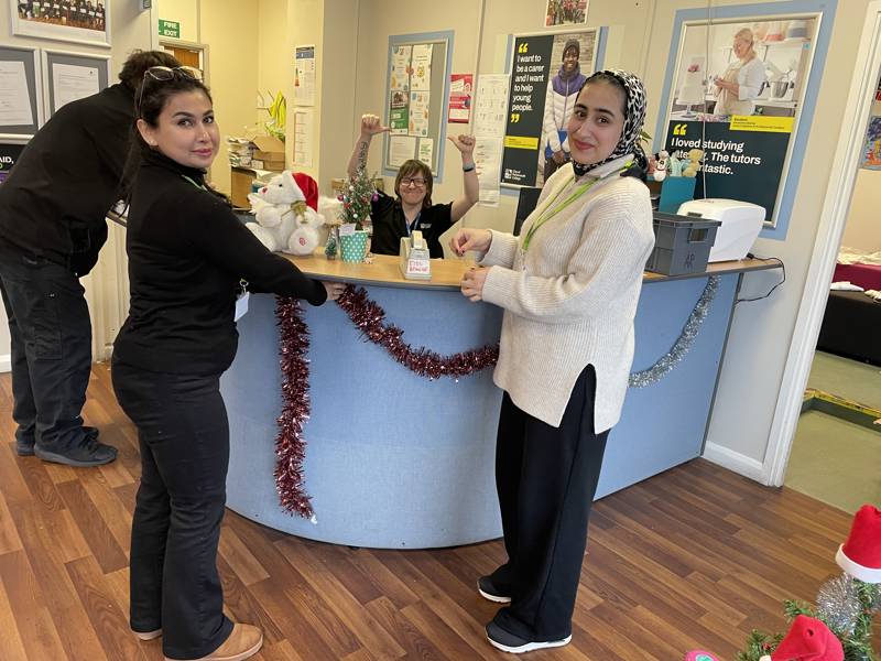 Female ESOL students put up Christmas decorations at Arundel Campus.