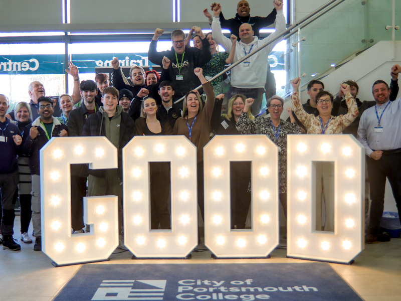 Students and staff at City of Portsmouth Colleges' North Harbour Campus surrounding good in light up letters