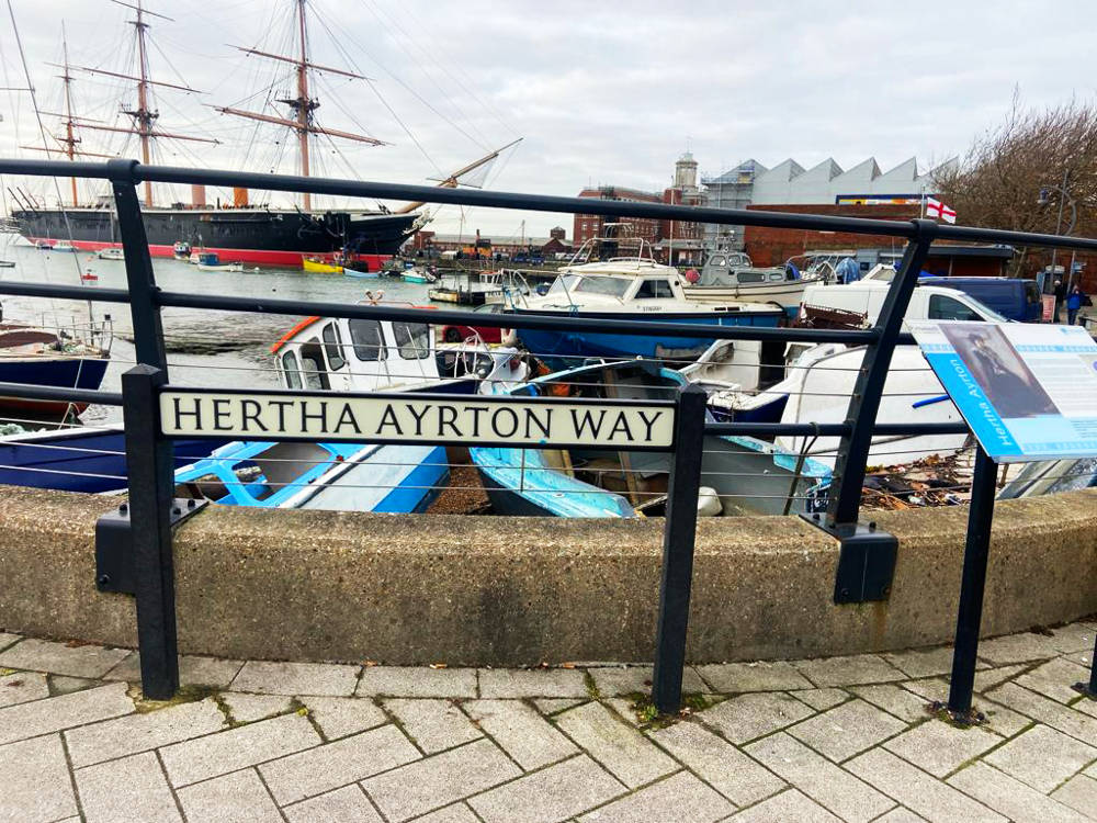 Hertha Ayrton Way road sign in Old Portsmouth with HMS Warrior in the background