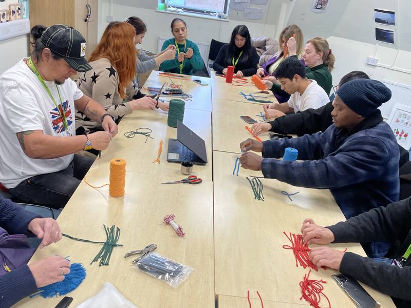 A group of ESOL students taking part in a macrame workshop.