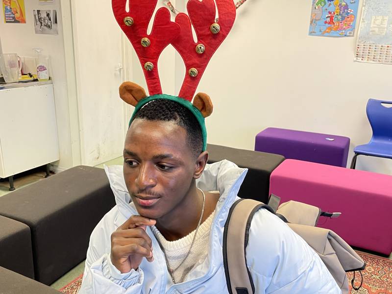 Male ESOL student wearing red reindeer antlers.