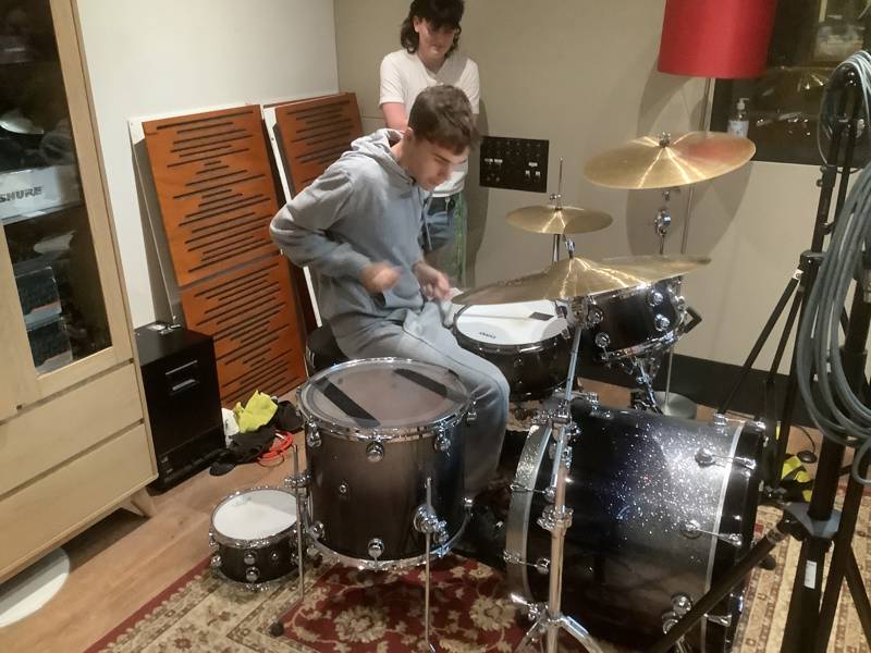 COPC student having a go on the drums at the Abbey Road Institute