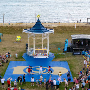 A group of people watch the City of Portsmouth College flashmob dance at Southsea Bandstand