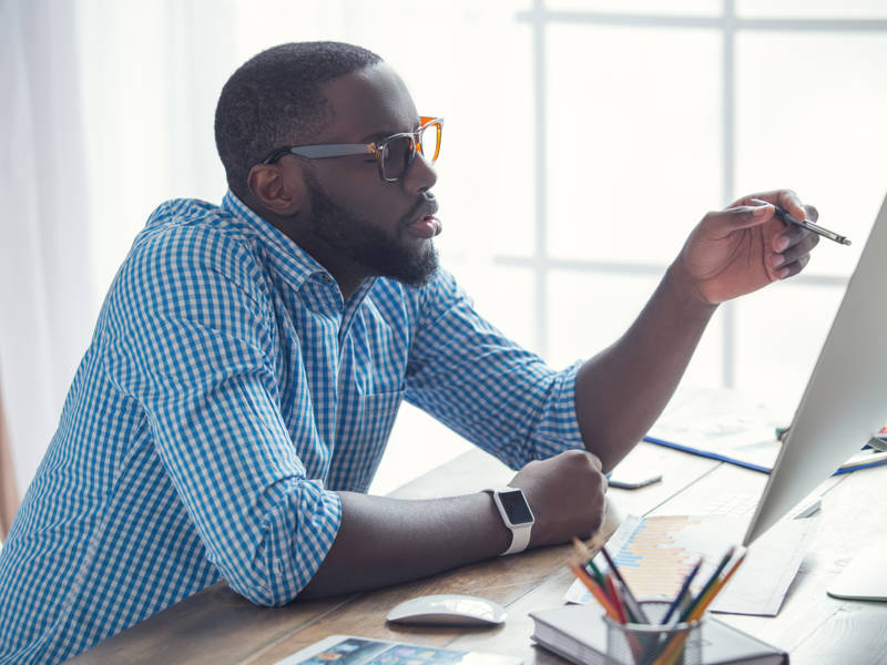 Male adult student looks at computer screen