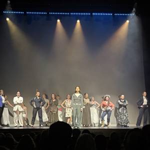 The cast of Pinnacle on stage performing an ensemble number