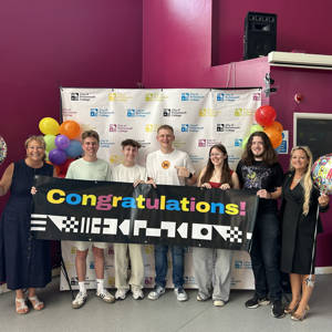 City of Portsmouth College students hold a congratulations banner on A Level results day, accompanied by Katy Quinn, Principal and CEO, on the left, and Portsmouth North MP Amanda Martin, right.